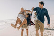 © Marko Geber - Grandfather and father swinging child on the beach during family vacation