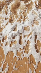 Poster - Soft white sea foam creates intricate patterns as it gently washes over the golden sand of a sunny beach, offering a tranquil and mesmerizing view of nature's artistry