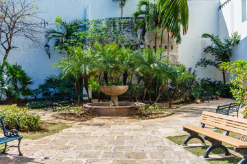 Wall Mural - A courtyard with a fountain and a bench