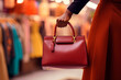 © JEROSenneGs - Woman browsing for a discounted designer handbag at a luxury boutique.