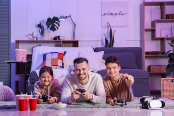 Canvas Print - Father with his children playing video game on floor at home in evening