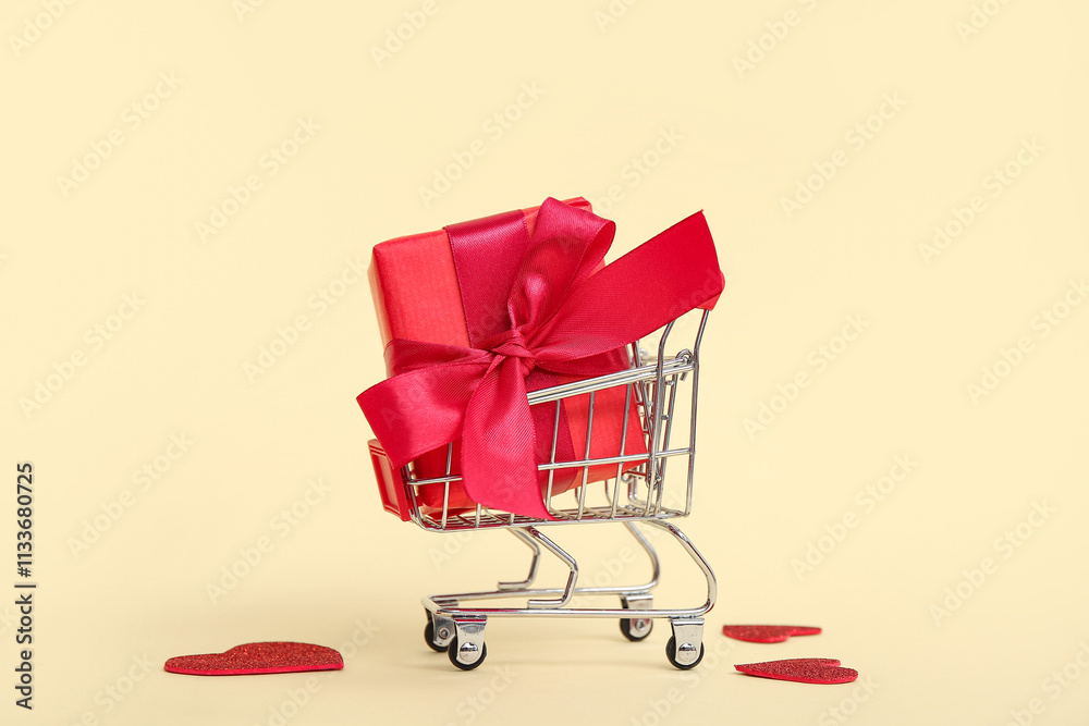 Mini shopping cart with gift box on yellow background. Valentine's Day celebration