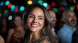 © maesarin - Radiant woman in an elegant evening gown smiling joyfully at a celebratory event with a blurred lights background creating a festive atmosphere
