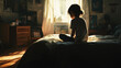 © Shanorsila - A child sitting on the edge of a bed, staring blankly at the floor, soft light casting long shadows in a cluttered bedroom.