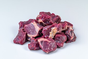 Poster - Close-up of raw beef cubes on white background.