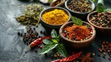 A vibrant assortment of spices in bowls, showcasing various colors and textures, surrounded by herbs and dried chilies on a textured surface.
