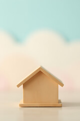 Poster - A miniature wooden model of a house with a soft pastel colored sky in the background is created._00002_