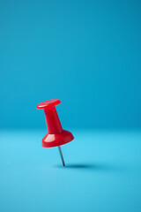 Poster - A business concept is presented using a successful idea of a red pin and thumbtack against a blue background in selective focus._00001_