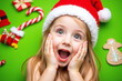 © AuraBloom - Young child in Santa hat showing excitement