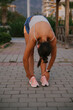 © teksomolika - An athlete is stretching in preparation for a workout in an urban outdoor setting