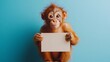 © thongsook - A playful animal with ginger tones holding or near a blank sign, placed against a bright blue background for contrast