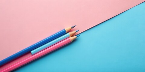 A trio of colored pencils rests on a pink and blue background, offering a playful visual of creativity and artistic expression.