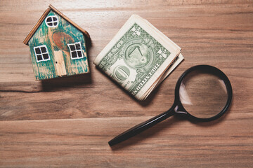 Wall Mural - magnifying glass with miniature house on wood table. property and real estate concept