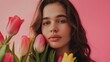 © Vikarest - a beautiful woman with bunch of tulips on a pink background