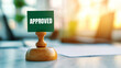 © Supapich - Approved stamp on wooden base in bright office setting
