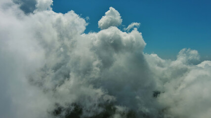Wall Mural - Flying through white fluffy clouds