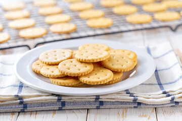 Wall Mural - Traditional round crackers are cooling after baking on a rack on a white table, selective focus.