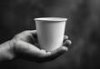 © Людмила Мазур - Hand holding a cup of milk. The cup is made of plastic and is filled with milk. The image has a simple and straightforward concept, but it also has a mood of loneliness or solitude