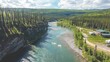 © MetaKibo - Aerial view of a river winding through lush green forests and hills.