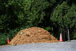 © knelson20 - Large pile of wood chips fresh from the woodchipper on a gravel park parking lot, ready for grounds keeping maintenance