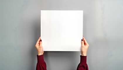 Poster - Woman holds blank paper sheet. Hands hold empty poster. Blank space for design. Gray background. Possible ad, presentation, or message. Elegant business style. Versatile marketing material.