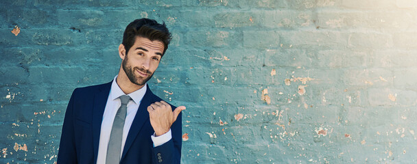 Poster - Pointing, portrait and space with businessman on wall background for advertising or marketing. Banner, offer and promotion with confident corporate employee showing announcement or information
