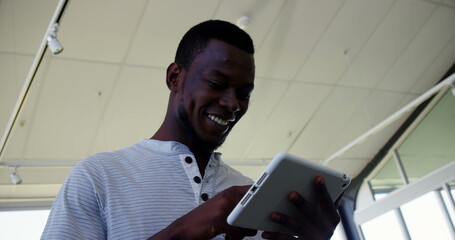Poster - Smiling man using tablet in modern office, enjoying digital content