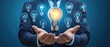 © Gambar Upi - Light bulb with innovation icons in businessman’s hand. Concept of business creativity and solutions