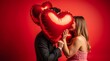 © Natsumae - Passionate couple's Valentine's Day kiss, hidden behind large red heart-shaped balloons against a vibrant red backdrop.