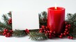 © Ti Studio - A red Christmas candle resting on a wreath of pine sprigs and berries, next to a blank card, isolated on white