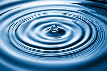 Wall Mural - close-up view of circular water ripples created by a droplet falling on calm water surface, evoking 