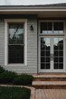 © MatandSterre - Front entrance of a house featuring double glass doors, windows, and landscaped steps leading to the porch.