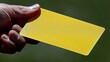 © PaulShlykov - Referee issues yellow card during an intense soccer match in a sunny stadium