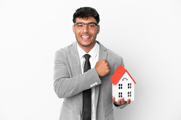 Poster - Business man holding a house isolated on blue background celebrating a victory