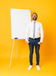 © luismolinero - Full-length shot of businessman giving a presentation on white board over isolated yellow background shouting to the front with mouth wide open