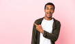 © luismolinero - African American man on copyspace pink background surprised and pointing side