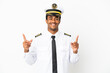 © luismolinero - African American Airplane pilot over isolated white background pointing up a great idea