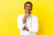 © luismolinero - African American Telemarketer man working with a headset over isolated yellow background smiling