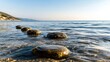 © siriporn - Calm ocean waves washing over submerged stepping stones'