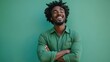 © Popelniushka - Confident African-American Male Entrepreneur in Green Shirt Laughing with Arms Crossed