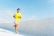 © muse studio - Man runs along a sunny white pathway with blue sky backdrop during a morning workout session