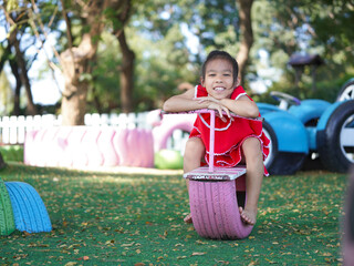 Cute girl playing in the playground during summer vacation. Happy children having fun in an outdoor park.