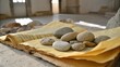 © Collection - An aged book with delicate, yellowed pages, resting on a worn surface, holds a collection of smooth stones, capturing a moment of quiet reflection.