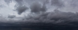 The dark sky filled with swirling clouds forebodes an approaching windstorm, showcasing the power of nature's forces and the dramatic shifts in weather during turbulent atmospheric conditions.