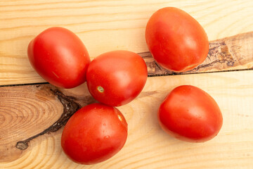 Wall Mural - Fresh juicy tomatoes on a wooden table, close-up, top view.