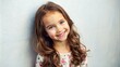 © Владлена Демидова - Smiling young girl with brown hair, children’s fashion ad against light wall.