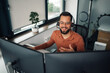 © Zamrznuti tonovi - Smiling businessman having video call and working from home office using dual monitor setup