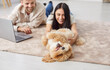 © Studio Romantic - Family couple playing with dog at home, enjoying leisure time together. The pet owners interact with animal in a warm domestic environment, highlighting the bond between them and pet.