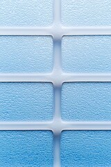 Poster - Textures of blue frosted glass panels interspersed with white frames creating a modern and cool aesthetic.