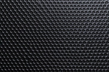 Poster - A textured black wall featuring a pattern of raised circular elements creating an intriguing visual depth.